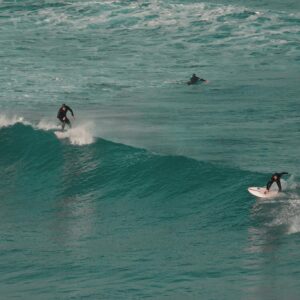 Surfers riding ocean waves capture thrill of surfing at a vibrant coastal location.