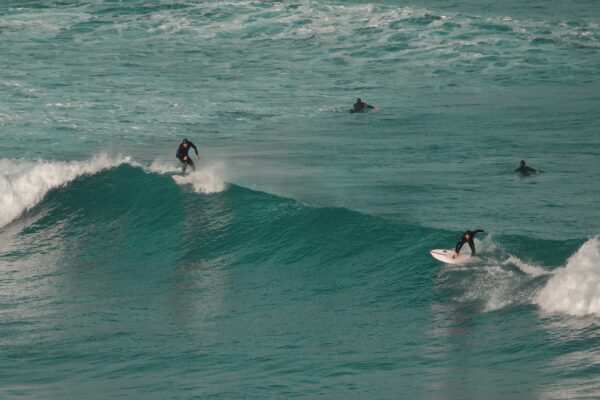 Surfers riding ocean waves capture thrill of surfing at a vibrant coastal location.