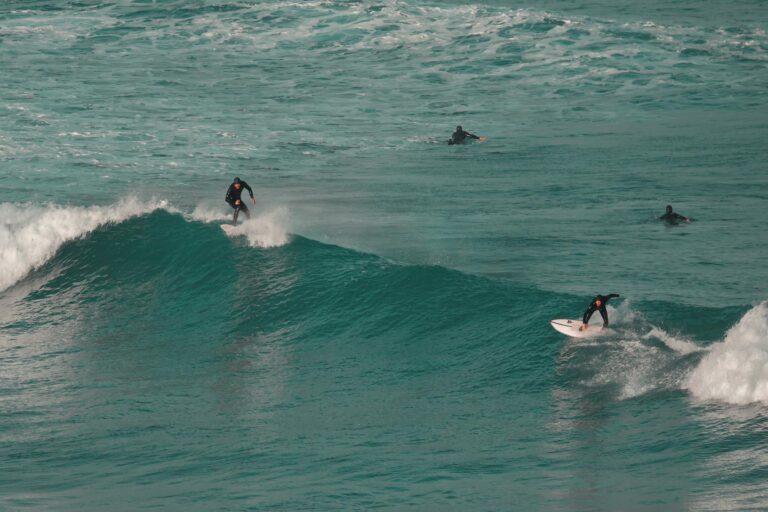 Surfers riding ocean waves capture thrill of surfing at a vibrant coastal location.